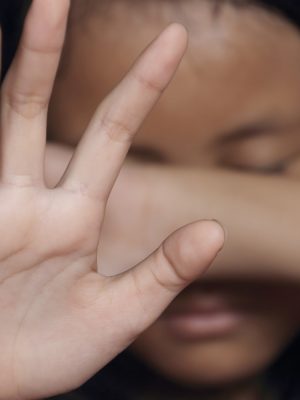 Little girl suffering bullying raises her palm asking to stop the violence