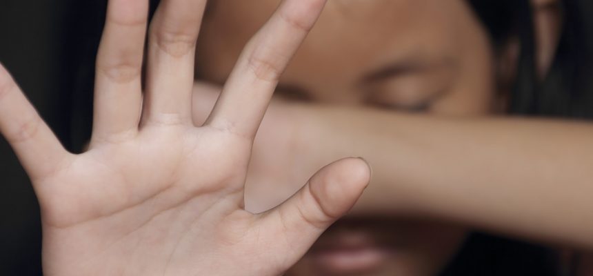 Little girl suffering bullying raises her palm asking to stop the violence