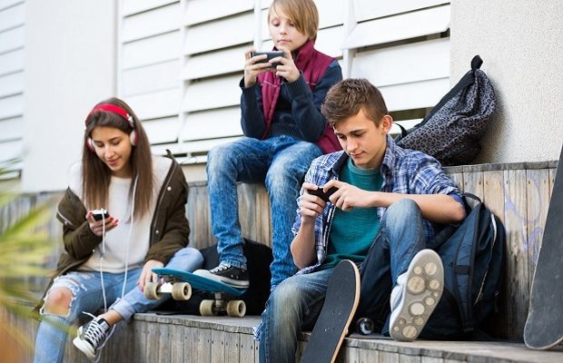 Three teenagers with smartphones